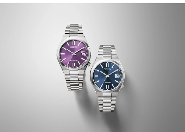 Citizen Tsuyosa 37, Referenz NJ0200-50W und NJ0200-50M, zwei Uhren mit blauem und violettem Zifferblatt vor grauem Hintergrund