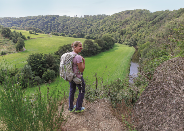 Die Autorin auf einem Wanderweg vor einem Ausblick auf einen Wald