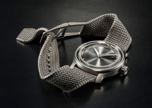 Ming-Polymesh mit Uhr, liegend vor grauem Hintergrund