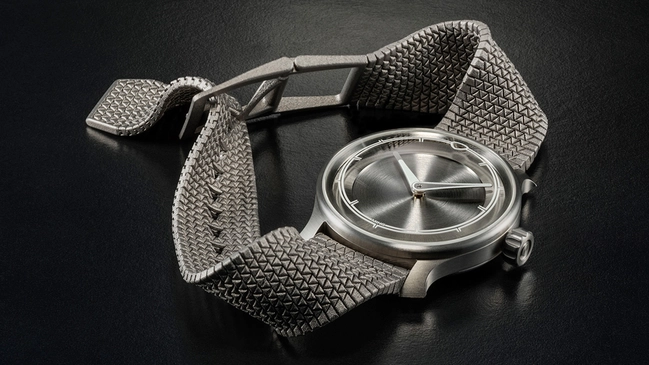 Ming-Polymesh mit Uhr, liegend vor grauem Hintergrund