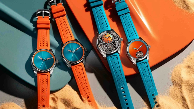 H. Moser & Cie. Pioneer Spiced Aqua, drei Uhren mit Taucherflossen im Hintergrund