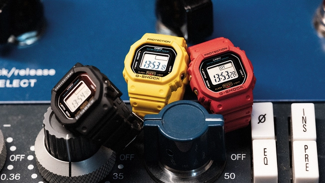G-Shock DWN-5600 Uhr im Ringformat, drei Modelle vor Stereoanlage