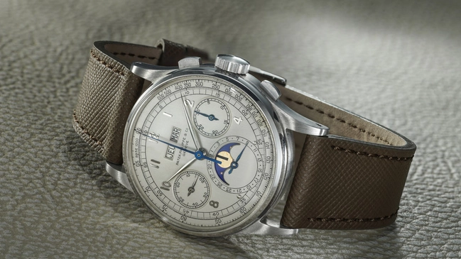 Patek Philippe Ref. 1518 in Stahl liegend vor grauem Hintergrund