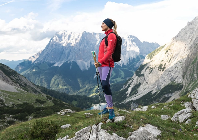 Wanderin stehend mit Blick in die Ferne auf das Bergpanorama.