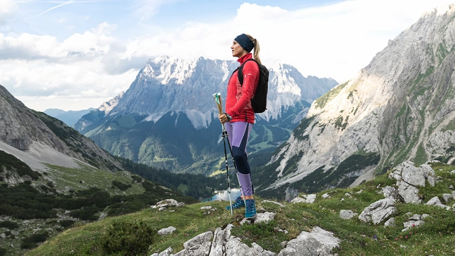 Wanderin stehend mit Blick in die Ferne auf das Bergpanorama.