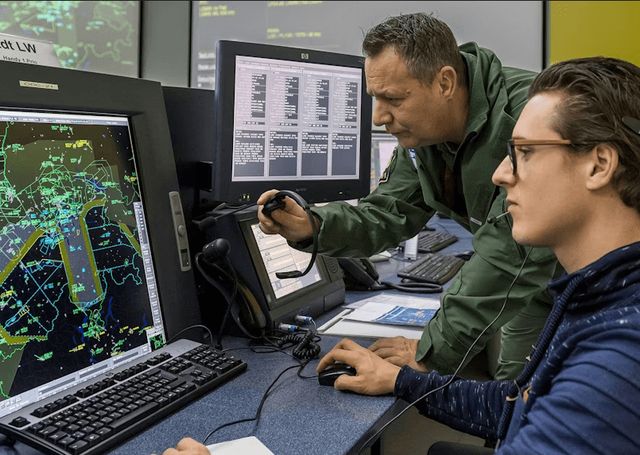 Fluglotse und Chief Air Defense Officer vor dem Überwachungssystem