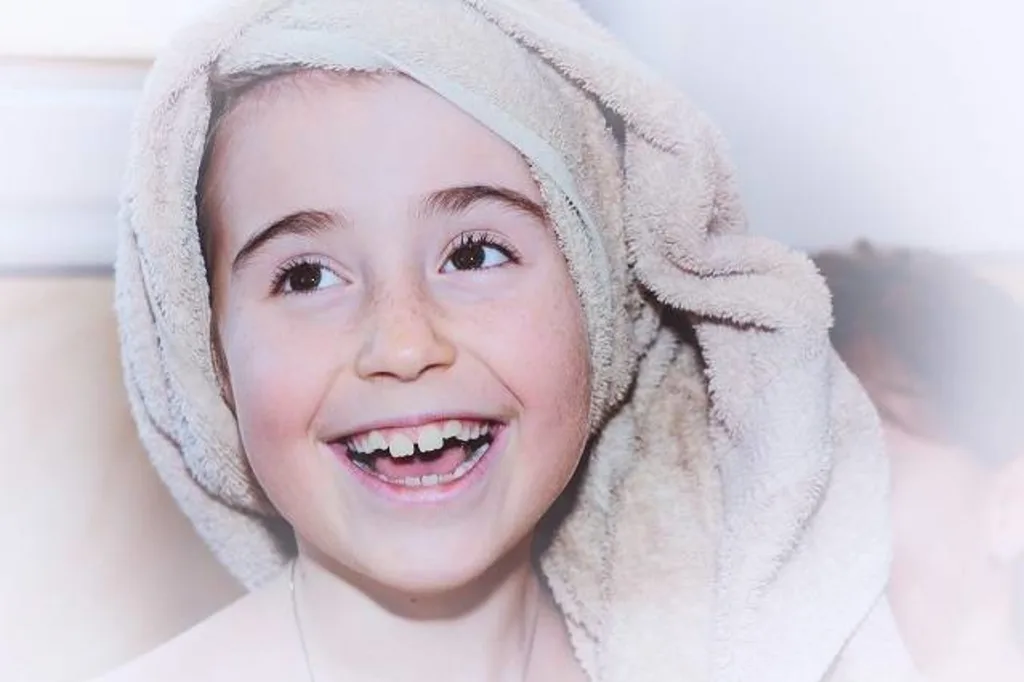 Lachendes Kind mit Handtuch um den Kopf