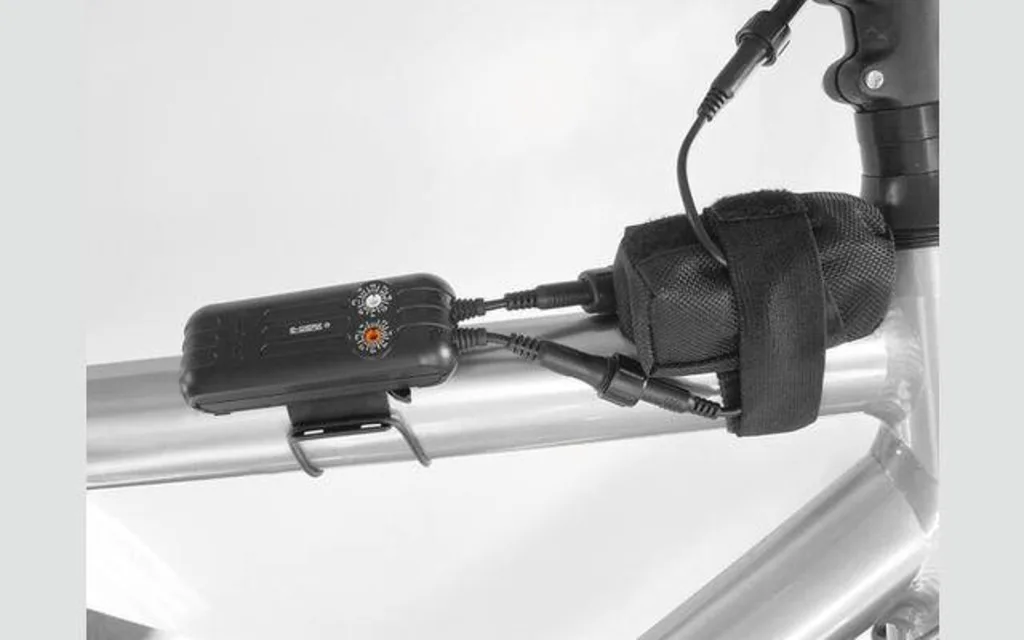 Kleines, an den Velorahmen geschnalltes Gerät mit zwei Kabeln