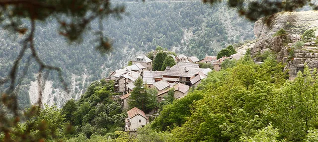 Blick von Oben auf ein französiches Bergdorf am Hang.