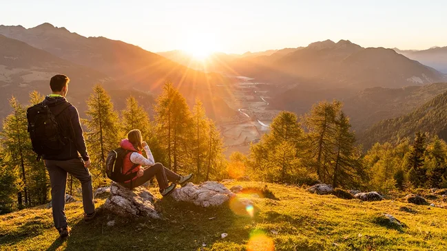 Ausblick auf Bergkulisse mit Sonne am Horizont.