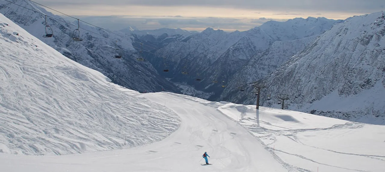 Skifahrer auf Piste vor weitem Bergpanorama im Aostatal.