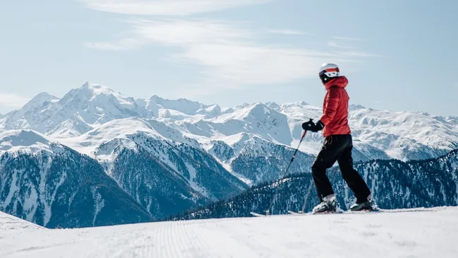 Person auf Ski vor verschneitem Bergpanorama in der Zwei Länder Skiarena.