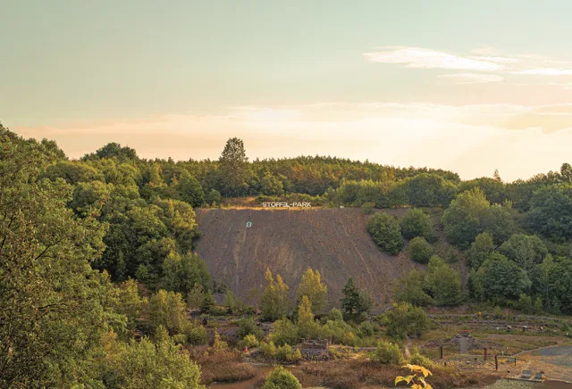 Blick auf einen Erdwall mit dem Schriftzug Stöffelpark darauf