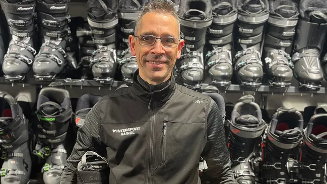 Bootfitter Matthias Schmidt vor Skischuhwand.