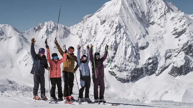 Jubelnde Skifahrer vor Bergpanorama