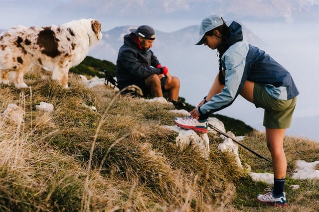 Zwei Wanderer gehen auf einem Wanderweg vor Bergpanorama