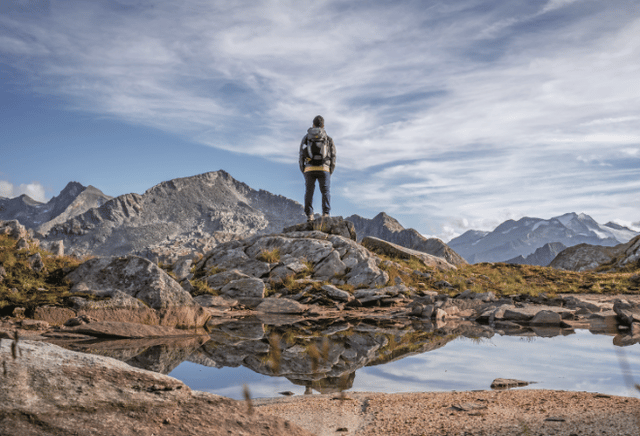Einzelner Wanderer von hinten vor einer Bergkulisse