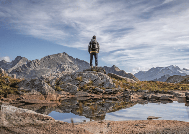 Einzelner Wanderer von hinten vor einer Bergkulisse