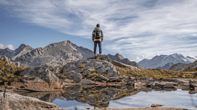 Einzelner Wanderer von hinten vor einer Bergkulisse