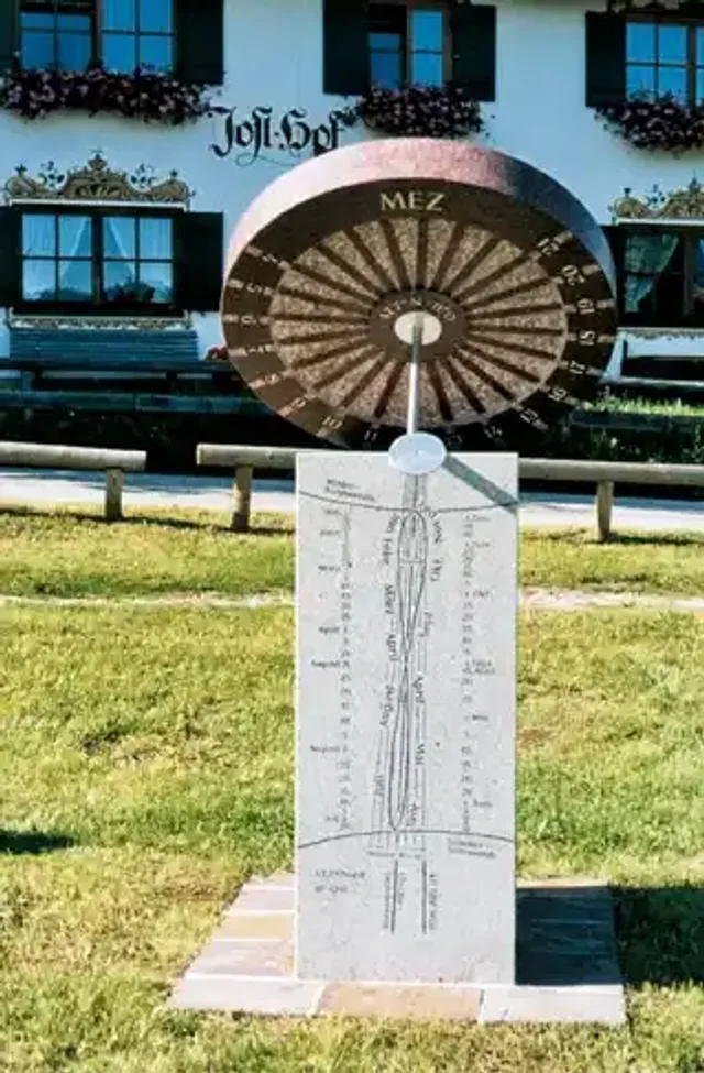 Süd-Zifferblatt der Wagenrad-Sonnenuhr mit Achterschleife auf dem Sockel