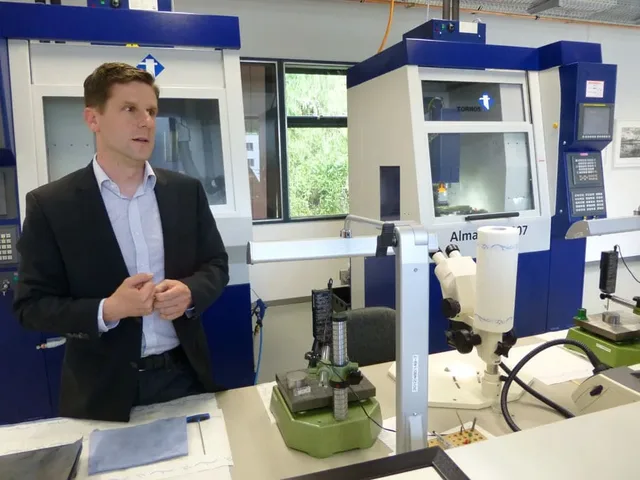 Konstrukteur Norbert Windegger erklärt die Einsatzmöglichkeiten der CNC-Maschinen im Hintergrund