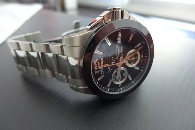 Das Zifferblatt des Longines Conquest Chronos gestalten silberfarben umrandete Totalisatoren bei der Sechs und Neun sowie eine unterbrochene Zwölf.