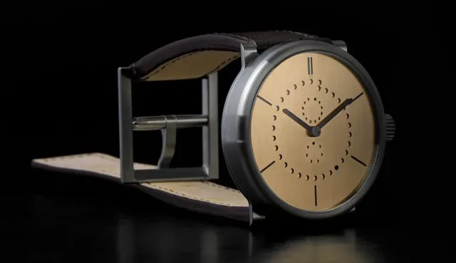 Die um das Zifferblatt laufende Punkte-Anzeige stellt das Datum dar, bei der Zwölf stehen die Monate, bei der Sechs die Wochentage.