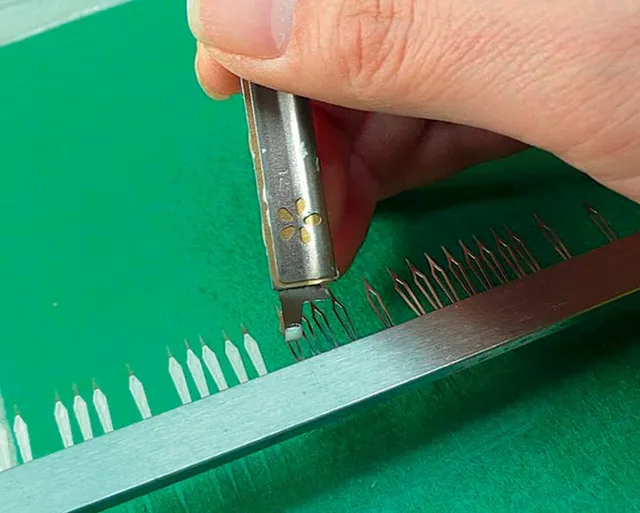 Das Auftragen von Leuchtfarbe auf die Zeiger kann Handarbeit sein.