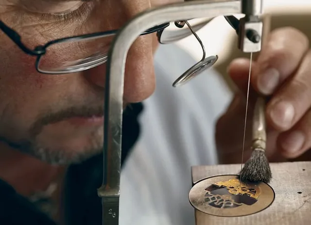 Der Skeletteur führt eine Säge durch das Metall des Uhrwerkteils