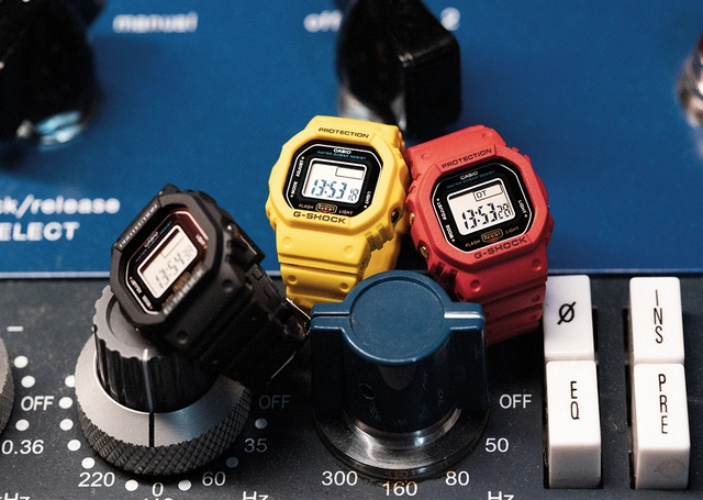 G-Shock DWN-5600 Uhr im Ringformat, drei Modelle vor Stereoanlage