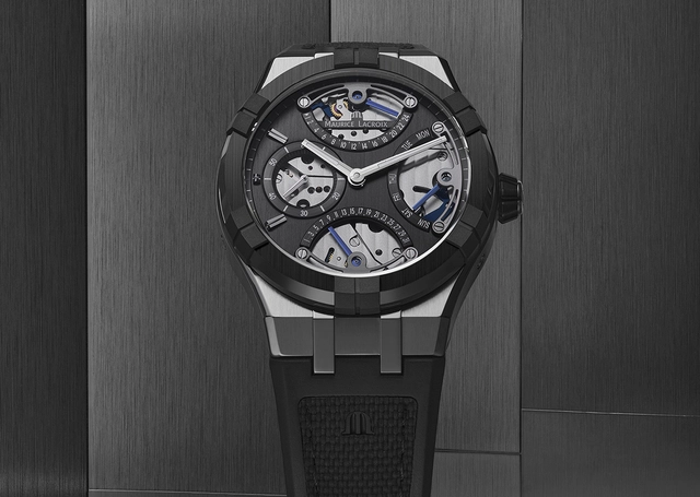 Maurice Lacroix Aikonic Master Triple Retrograde, Uhr vor grauem Hintergrund