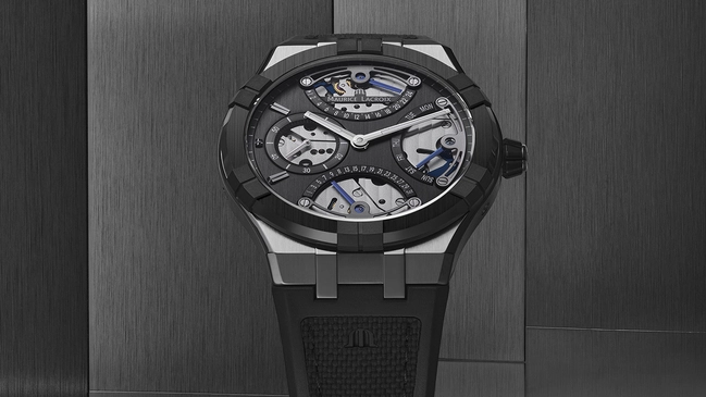 Maurice Lacroix Aikonic Master Triple Retrograde, Uhr vor grauem Hintergrund