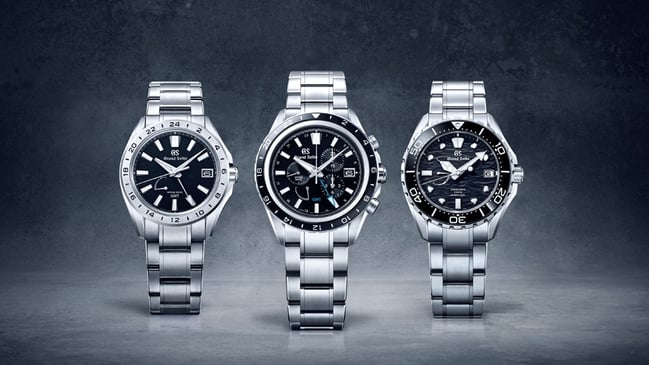 Die noch junge Kollektion Evolution 9 basiert wie alle Uhren von Grand Seiko auf dem 1967 geschaffenen Modell 44GS, weist aber mit einer verbesserten Ablesbarkeit und ihrem hohen Nutzungskomfort in Richtung Zukunft. Die Neuheiten der aktuellen Uhrensaison bestehen allesamt aus dem Grand-Seiko-typischen kratzfesten High-Intensity-Titanium und werden von Spring-Drive-Kalibern angetrieben. Diese von der japanischen Manufaktur erfundene Technik verbindet ein mechanisches Kaliber inklusive Räderwerk, Federhaus und Aufzugsmechanismus mit einem elektronischen Gangregler, der für eine zuvor ungekannte Präzision sorgt. Ein Highlight unter den Neuheiten ist der Evolution 9 Spring Drive Chronograph GMT 9R96 (Referenz SBGC251, Bild Mitte), der eine Stoppfunktion, eine zweite Zeitzone, ein Datum und eine Gangreserveanzeige vereint. Das umfangreiche Funktionsensemble findet in einem 45,3 Millimeter großen Gehäuse Platz. Die Chronographenzähler für Stunden und Minuten liegen in der rechten Zifferblatthälfte nah beieinander, was die Ablesbarkeit verbessert. Die Gangreserve beträgt drei Tage, die Wasserdichtheit zehn Bar. Mit zwei Saphirgläsern und Sicherheitsfaltschließe kostet das Modell 11500 Euro. Abgesehen vom Chronographen bietet die neue Evolution 9 Spring Drive GMT 9R66 (Referenz SBGE283, Bild links) die gleichen Funktionen und eignet sich damit ideal für Reisende oder für Geschäftsleute, die vom Büro aus verschiedene Zeitzonen im Blick behalten müssen. Für 8500 Euro geht die 41 Millimeter große Uhr mit ihrem neuen Besitzer auf Reisen. Die sportlichste Neuheit ist die bis 200 Meter wasserdichte Taucheruhr Evolution 9 Spring Drive 5 Days-Kaliber 9RA5 (Referenz SLGA015, Bild rechts). Die schwarze Farbe und die aufwendige Struktur des Zifferblatts sind inspiriert von den dynamischen Gezeiten des Kuroshio-Stroms, auch Schwarzer Strom genannt, der Japan in Richtung Nordpazifik passiert. Das Spring-Drive-Kaliber bietet zwei Besonderheiten: eine erhöhte Gangdauer von fünf statt drei Tagen sowie eine noch weiter gesteigerte Präzision von maximal zehn statt 15 Sekunden Abweichung – im Monat!