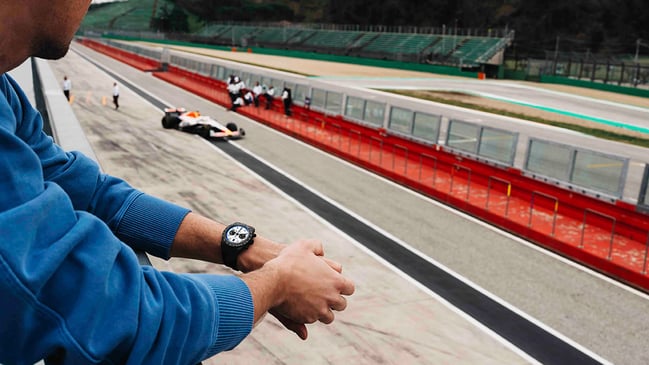Tudor Black Bay Chrono Carbon 25 am Handgelenk vor Rennstrecke