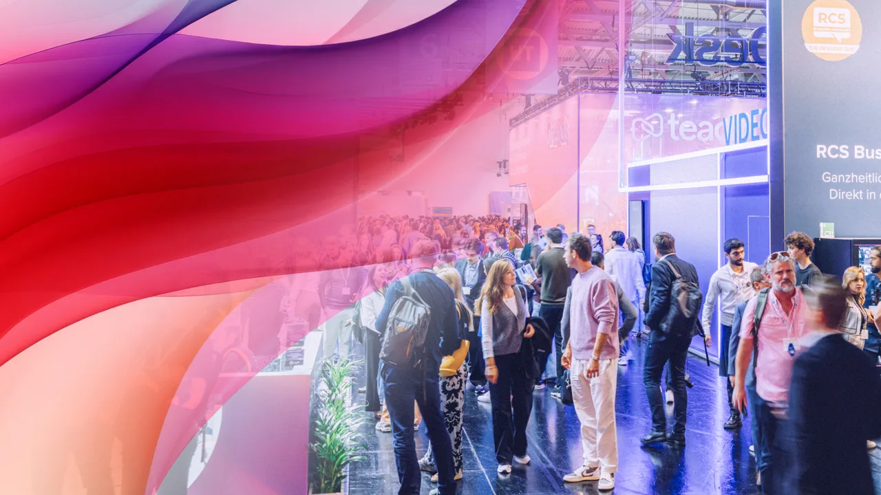 Messehalle mit vielen Besuchern an Ausstellungsständen; darüber liegt eine abstrakte Wellen-Grafik in Pink-, Rot- und Lilatönen.
