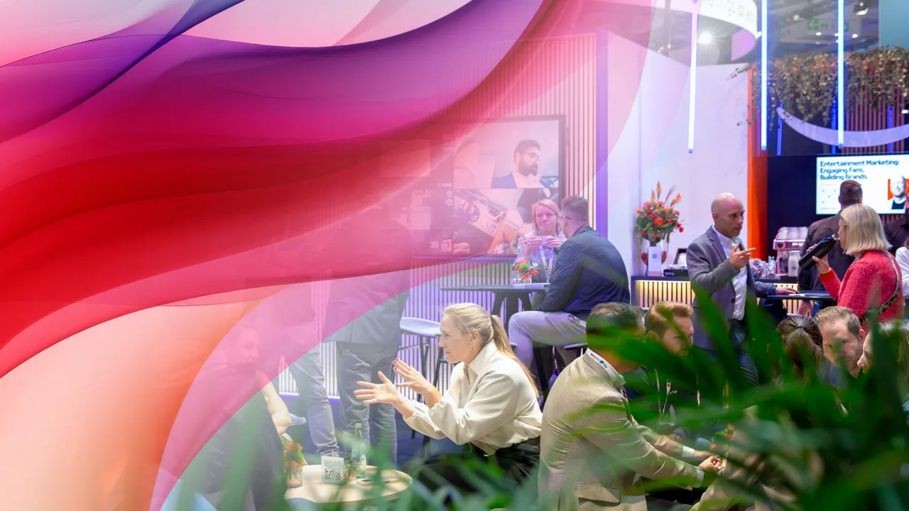Messe- und Gesprächsszene an einem Stand mit mehreren Personen, darüber eine abstrakte Wellen-Grafik in Pink-, Rot- und Lilatönen.